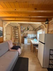 a kitchen and a living room with a refrigerator at Sosnowy Domek in Zator