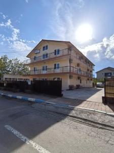 a large yellow building with balconies on a street at Sea Breeze Costinești in Costinesti