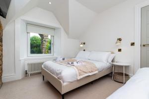 2 Bedroom Cottage-Free Parking في Newtongrange: غرفة نوم بيضاء مع سريرين ونافذة