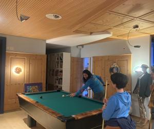 a woman playing pool in a room with a pool table at Gersau Hotel Fähri in Gersau