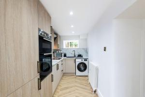 2 Bedroom Cottage-Free Parking في Newtongrange: مطبخ مع غسالة ومجفف ومغسلة