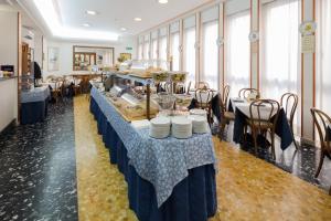 a buffet table in a room with tables and chairs at Hotel Terminus & Plaza in Pisa