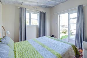 a bedroom with a bed and a window at Te Kōpuha in Tora