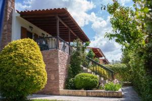 a brick house with a balcony and bushes at Bella Casa in Alexandroupoli