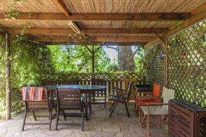 a patio with tables and chairs under a wooden pergola at Bella Casa in Alexandroupoli