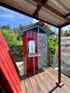 a red outhouse with a window on a deck at Redang Campstay A Frame in Redang Island