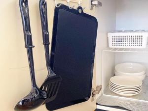 a black spatula hanging on a wall next to a toilet at kamui84 in Asahikawa +37 photos