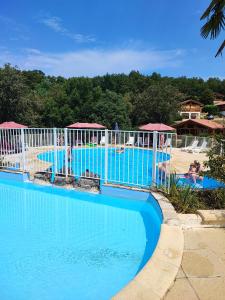 a pool at a resort with people swimming in it at Charmant Chalet LE DAMELI, Village du Soleil, Chalet 61 in Mauroux