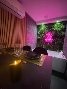 a table with a wine glass and a green wall at Le secret des déoux love room in Forcalqueiret