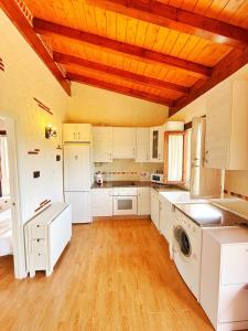a large kitchen with white cabinets and a wooden ceiling at La casita de Vera in Cabezón de la Sal