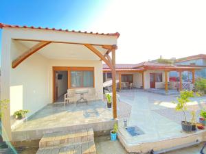 a home with a patio and a house at Daniela Apartments in Nea Roda