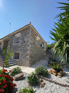 a stone house with some plants in front of it at Alexas Apartment in Myrina
