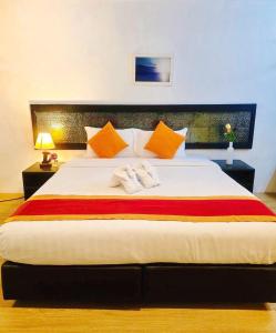 a bedroom with a large white bed with orange pillows at The Regizt Jomtien Pattaya in Jomtien Beach +32 photos