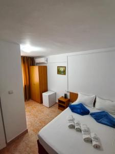 a bedroom with a white bed with blue sheets at Sea Breeze Costinești in Costinesti