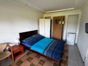 a small bedroom with a bed and a chair at POMERANIA Pokoje U Oliwii in Rewal