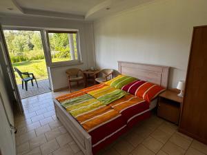 a bedroom with a bed and a table and a window at POMERANIA Pokoje U Oliwii in Rewal