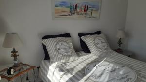 a bedroom with two twin beds with pillows with faces on them at La Maison LEON in Ychoux