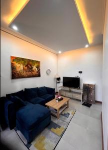 Una sala de estar con un sofá azul y una mesa. en Villa Teras Asri Seminyak, en Denpasar 14 fotos más