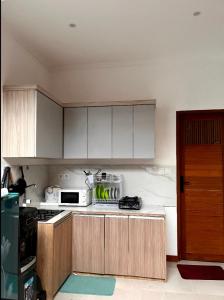 Una cocina con gabinetes blancos y encimera. en Villa Teras Asri Seminyak, en Denpasar