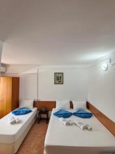 two beds in a room with blue and white at Sea Breeze Costinești in Costinesti