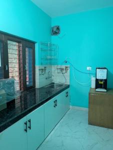 a blue room with a kitchen with a sink at Hilltop Heaven - One Bedroom Apartment in Mussoorie