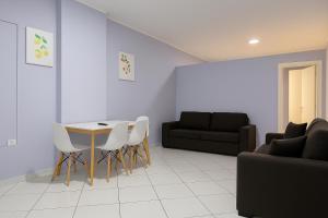 a living room with a table and chairs and a couch at AMMEN Rooms in Shëngjin