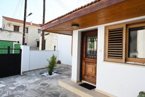 a house with a wooden door and a potted plant at ThemisHouse in Omodos
