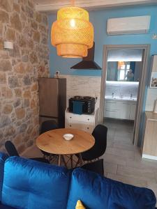a living room with a table and a blue couch at Aqua Retreat mani in Areopoli