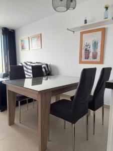 バルバテにあるApartamento Vista al mar primera en la playaのダイニングルームテーブル(黒い椅子、ソファ付)