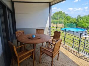 a balcony with a table and chairs and a pool at Chatka Katka in Klokočov