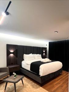 a bedroom with a large bed and a table at Hotel Europa Prishtina in Prishtinë