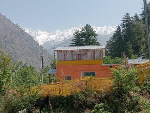 a building in the middle of a mountain at Yeti Stay Kasol in Jhungi