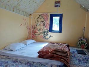 a bed in a room with a painting on the wall at Yeti Stay Kasol in Jhungi