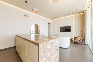 a kitchen with a counter and a living room at Even Residence Green Coast Palase in Palasë