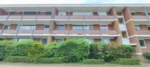 een appartementencomplex met struiken ervoor bij Stadtdomizil am Binnensee, Haus Bellevue in Heiligenhafen +4 foto's