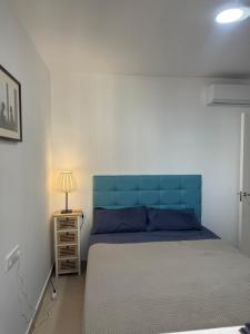 バルバテにあるApartamento Vista al mar primera en la playaのベッドルーム1室(青いヘッドボード付)