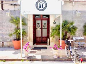 un edificio con una porta rossa con dei fiori davanti di Hotel Archimede Ortigia a Siracusa