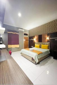 a large bedroom with a large bed with yellow pillows at Cahaya Prima Hotel in Jambi