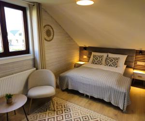 a bedroom with a bed and a chair and a window at Dom Wakacyjny Zielone Wzgórze in Mielno +63 photos