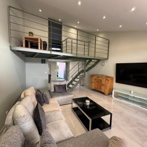 a living room with a couch and a loft at Maison au bord de la plage - Bottaï in Port-de-Bouc
