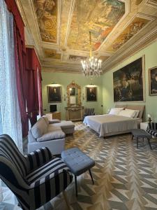 1 dormitorio con cama, sofá y sillas en Residenza d'epoca Palazzo Raffaele alla Maggiore, en Lamezia Terme