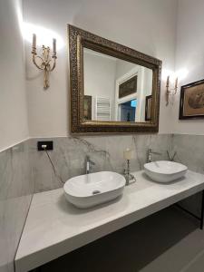 Un baño con dos lavabos y un espejo. en Residenza d'epoca Palazzo Raffaele alla Maggiore, en Lamezia Terme