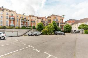 un parcheggio con auto parcheggiate di fronte agli edifici di T3 Terrasse parking Gare - Paris 30 min a Saint-Ouen-lʼAumône