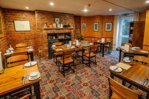a dining room with tables and chairs and a brick wall at The Camberley in Harrogate