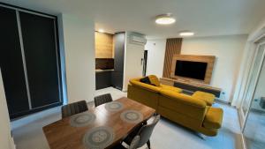 a living room with a yellow couch and a table at Fűzliget2 - Balaton Bliss in Balatonfůzfő