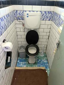 a small bathroom with a toilet with a black seat at AerowView Home Retreat in Matei +18 photos