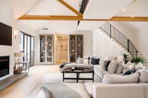 a living room with white furniture and a fireplace at Berry Luxury Barn House in Berry