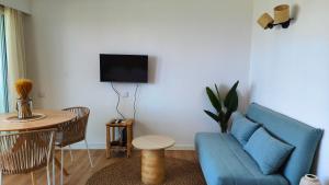 a living room with a blue couch and a table at Penthouse Studio Sea View in Alvor +6 photos