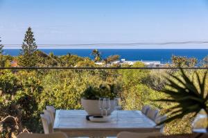 une table avec une plante en pot posée sur un balcon dans l'établissement ULTIMATE NOOSA Six Bedroom Luxury with WATERSLIDE!, à Sunrise Beach