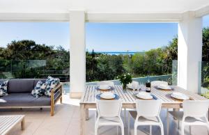 un patio avec une table, des chaises et un canapé dans l'établissement ULTIMATE NOOSA Six Bedroom Luxury with WATERSLIDE!, à Sunrise Beach 29 autres photos